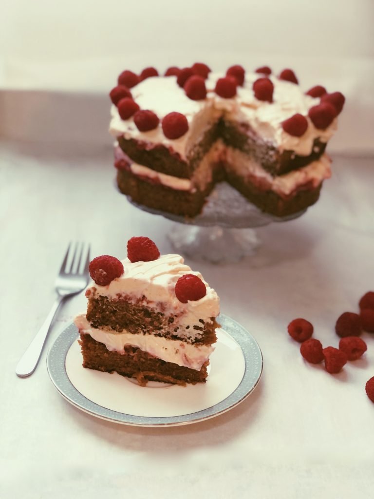 grain free raspberry-infused cake with raspberry jam and honey meringue frosting